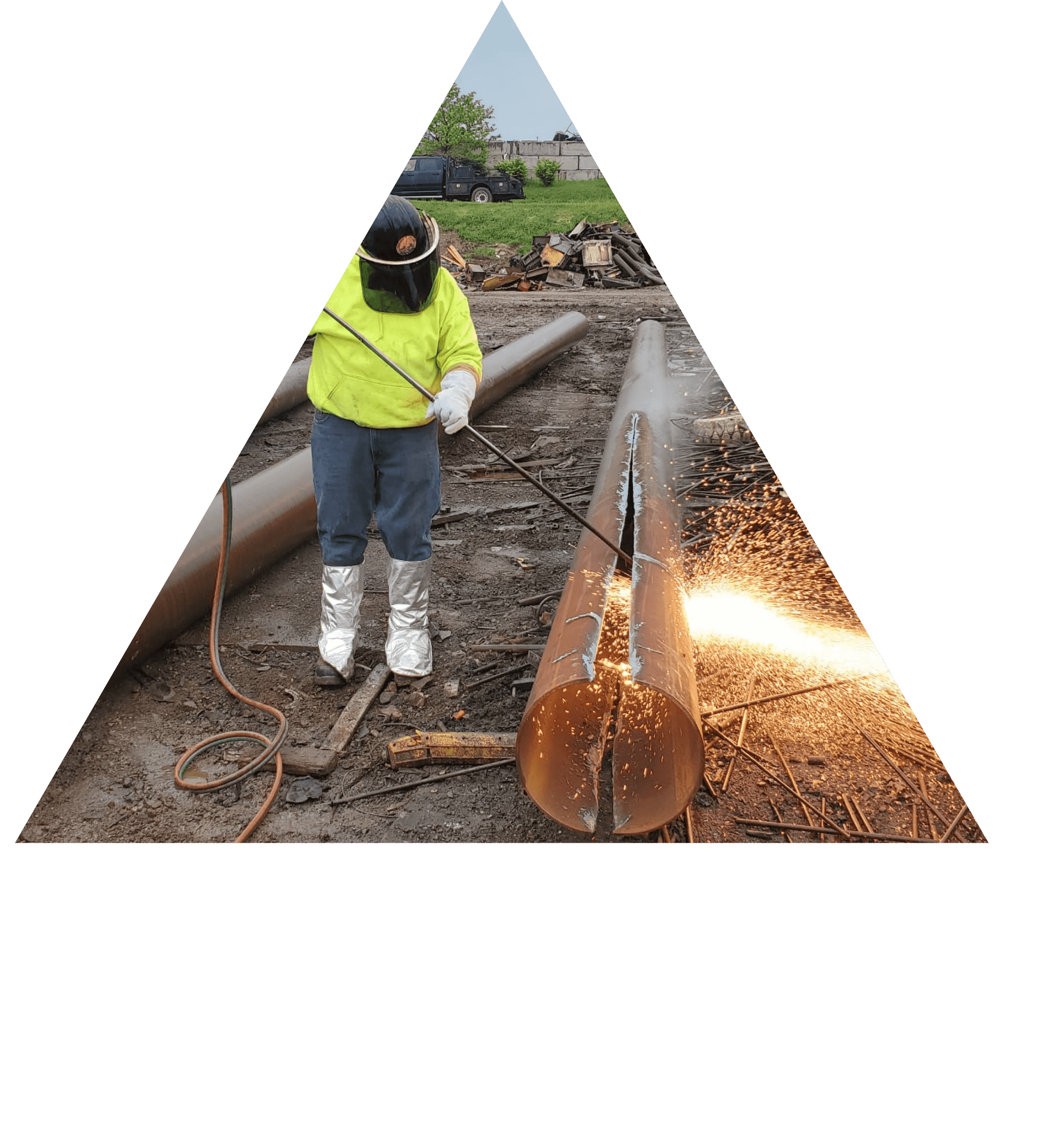 Worker performing torch cutting at a scrap yard, showcasing IMX Scrap Services' efficient on-site processing.